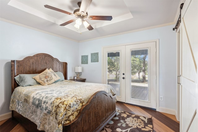 bedroom featuring a barn door, access to exterior, ceiling fan, and french doors