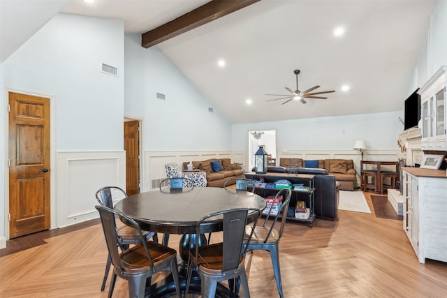 dining space with light parquet flooring, high vaulted ceiling, ceiling fan, and beam ceiling