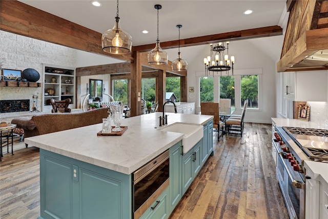 kitchen featuring plenty of natural light, wood-type flooring, sink, and an island with sink