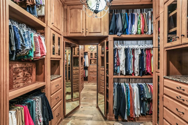 walk in closet with light hardwood / wood-style flooring