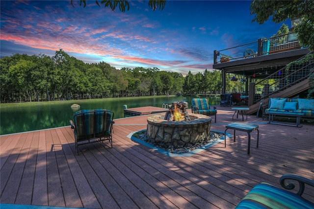 deck at dusk featuring a water view