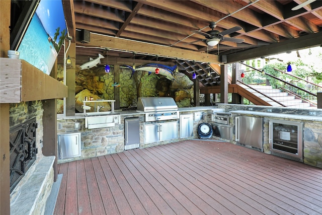 deck with area for grilling, beverage cooler, an outdoor kitchen, and ceiling fan