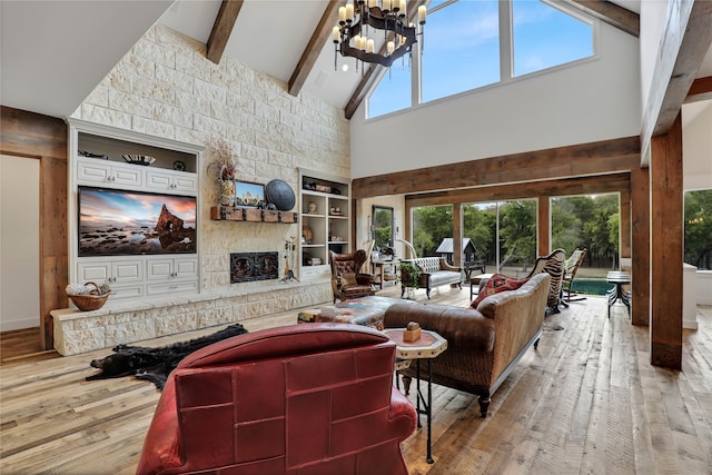 living room with beamed ceiling, hardwood / wood-style floors, a fireplace, and plenty of natural light