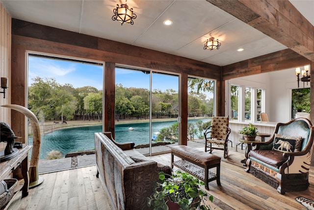 sunroom / solarium with a water view and a healthy amount of sunlight