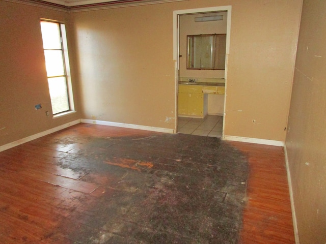 spare room with wood-type flooring and ornamental molding