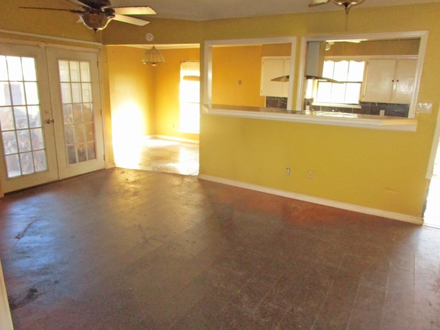 unfurnished living room with ceiling fan and french doors