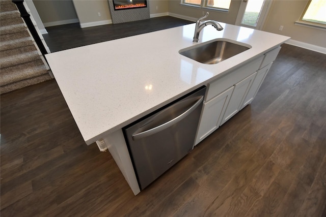 kitchen with white cabinetry, sink, dishwasher, dark wood-type flooring, and a kitchen island with sink