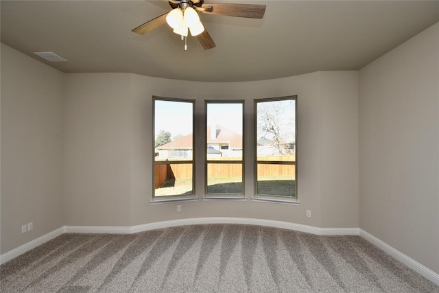 empty room featuring ceiling fan and carpet