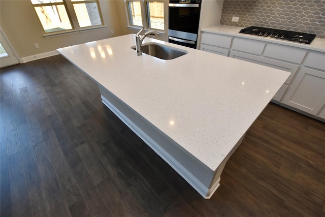 kitchen with backsplash, double oven, sink, dark hardwood / wood-style floors, and white cabinetry