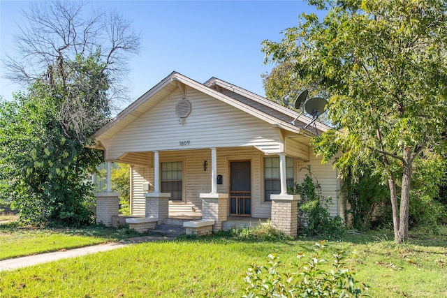 bungalow-style home featuring a porch and a front lawn