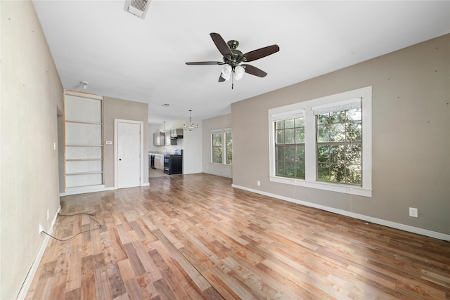 unfurnished living room featuring baseboards, ceiling fan with notable chandelier, light wood-type flooring, and visible vents