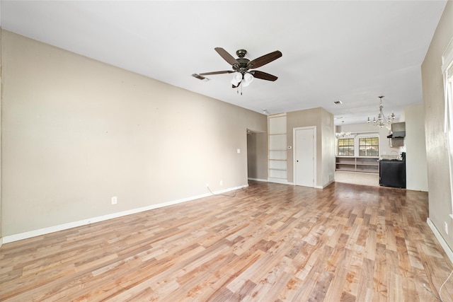 unfurnished living room featuring baseboards, ceiling fan with notable chandelier, light wood-type flooring, and visible vents