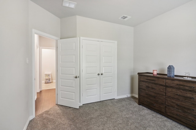 bedroom with light colored carpet and a closet