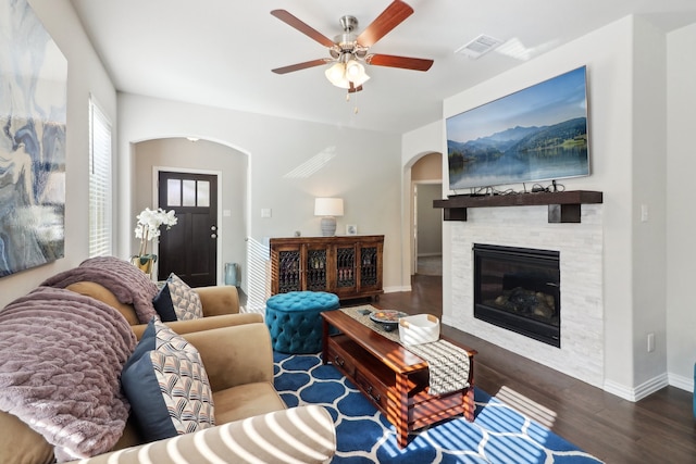 living room with ceiling fan, a fireplace, and dark hardwood / wood-style flooring