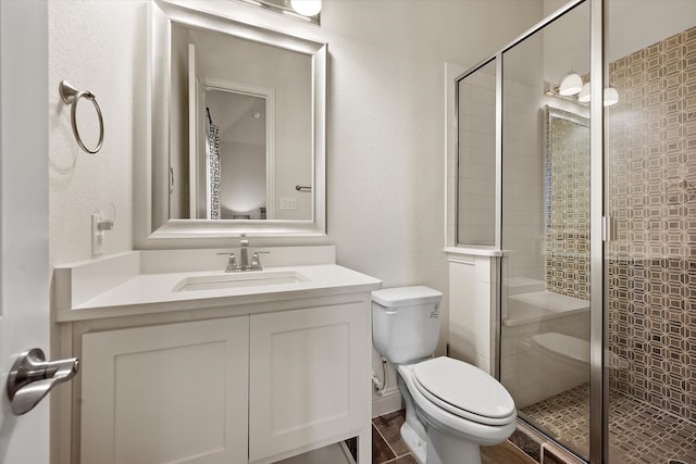 bathroom with toilet, a shower with shower door, and vanity