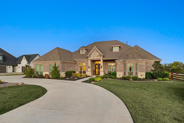 french provincial home featuring a front yard