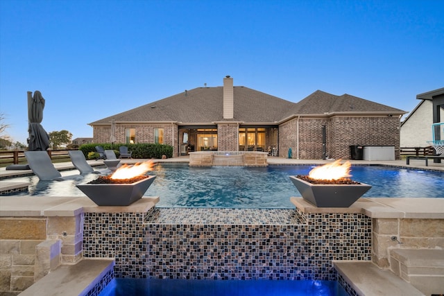 view of pool with an outdoor fire pit, a patio area, an outdoor hot tub, and pool water feature