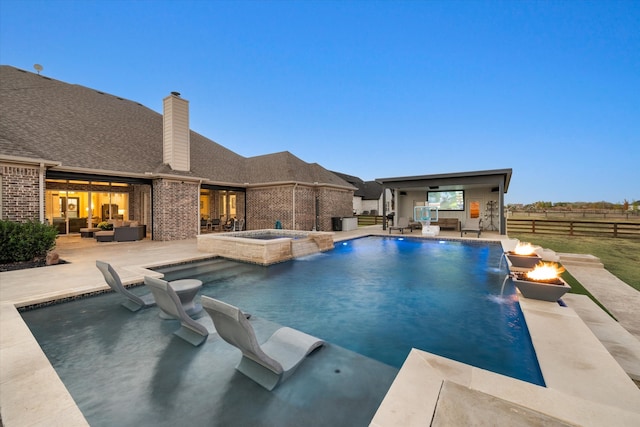 view of swimming pool with a patio area, pool water feature, and an in ground hot tub