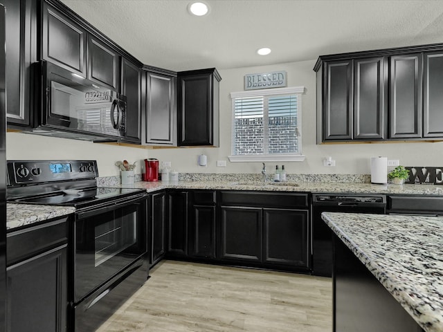 kitchen with light hardwood / wood-style flooring, sink, light stone countertops, black appliances, and a textured ceiling