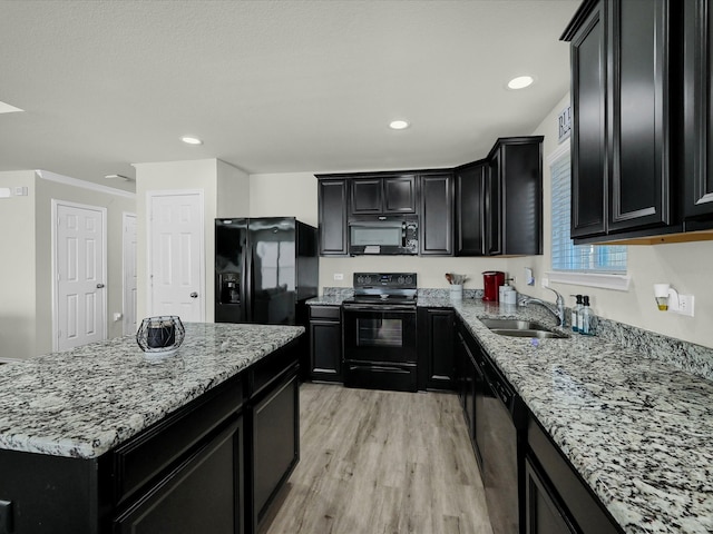 kitchen with black appliances, sink, light wood-type flooring, light stone counters, and ornamental molding