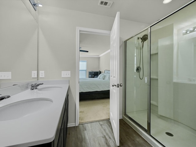 bathroom with a shower with door, hardwood / wood-style floors, and vanity