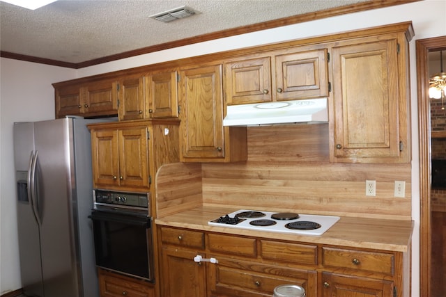 kitchen featuring a textured ceiling, stainless steel fridge, black oven, white stovetop, and ornamental molding