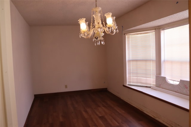 unfurnished room with a notable chandelier, a textured ceiling, and dark wood-type flooring