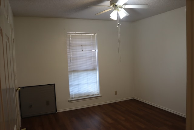 spare room with dark wood-type flooring, ceiling fan, and a textured ceiling