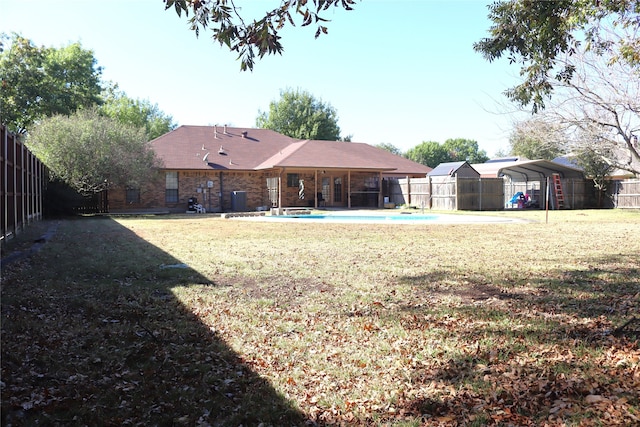 view of yard featuring a fenced in pool and a carport