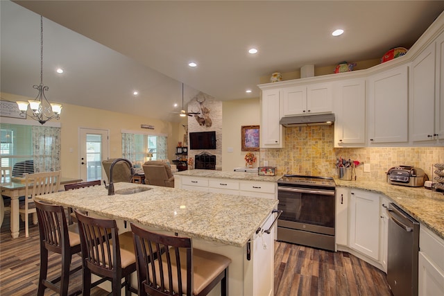 kitchen featuring sink, an island with sink, stainless steel appliances, pendant lighting, and dark hardwood / wood-style floors