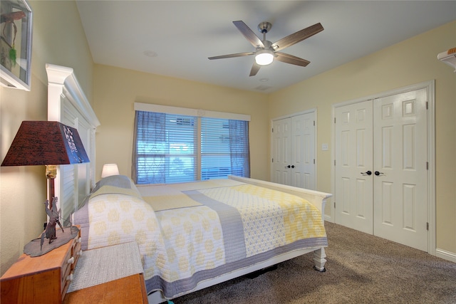 bedroom with ceiling fan, multiple closets, and carpet