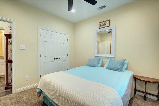 bedroom with a closet, dark carpet, and ceiling fan