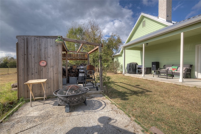 view of patio with an outdoor living space with a fire pit and a grill