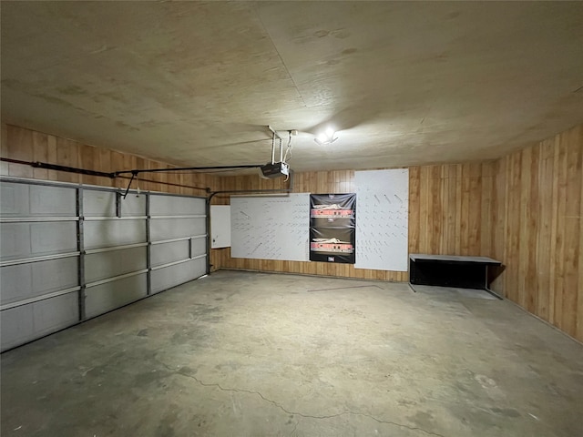 garage with wood walls and a garage door opener