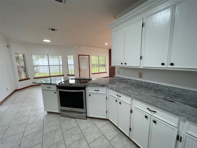 kitchen with kitchen peninsula, white cabinetry, light tile patterned flooring, and electric stove