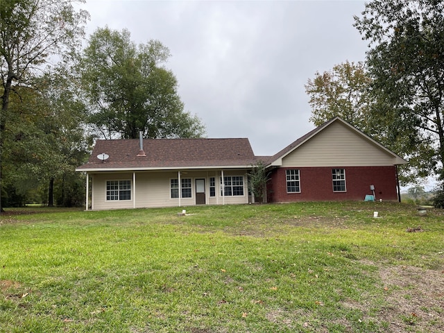 rear view of house featuring a lawn