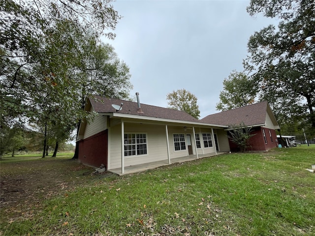 rear view of property with a lawn