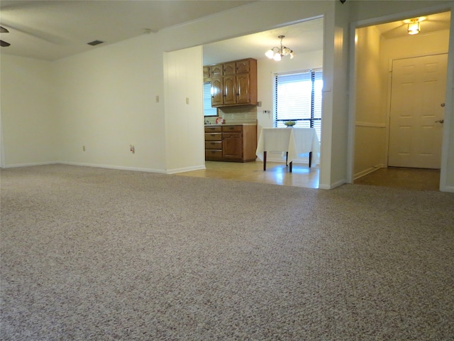 unfurnished living room featuring ceiling fan with notable chandelier