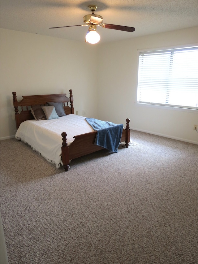 carpeted bedroom featuring a textured ceiling and ceiling fan