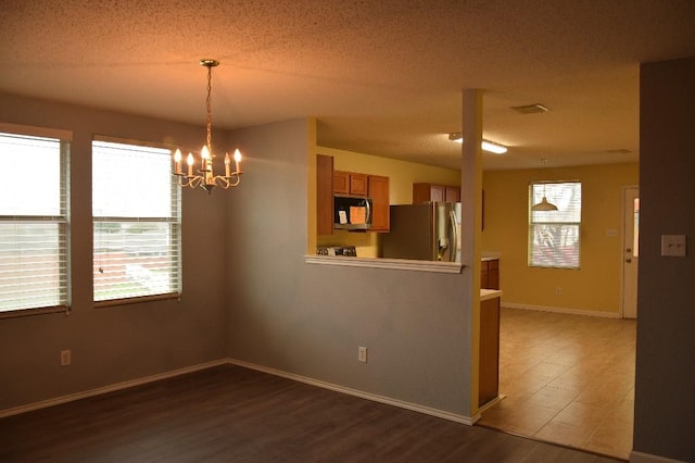 interior space featuring plenty of natural light, wood-type flooring, and a textured ceiling