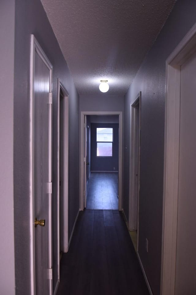 hall featuring dark hardwood / wood-style floors and a textured ceiling