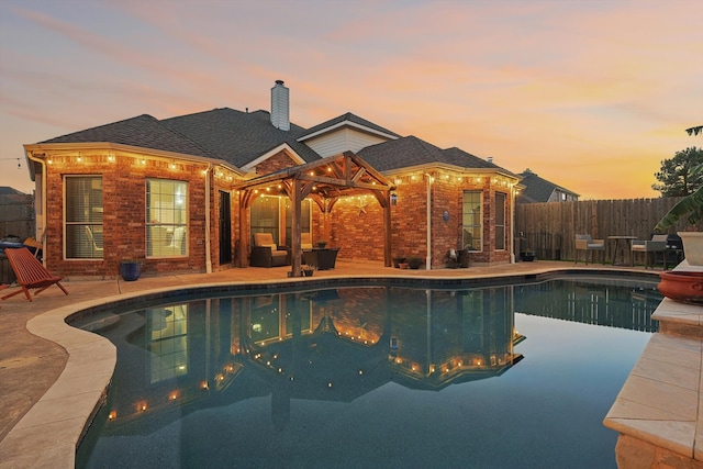 pool at dusk with a patio