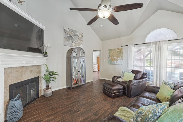 living room featuring high vaulted ceiling, wood finished floors, a fireplace, baseboards, and ceiling fan