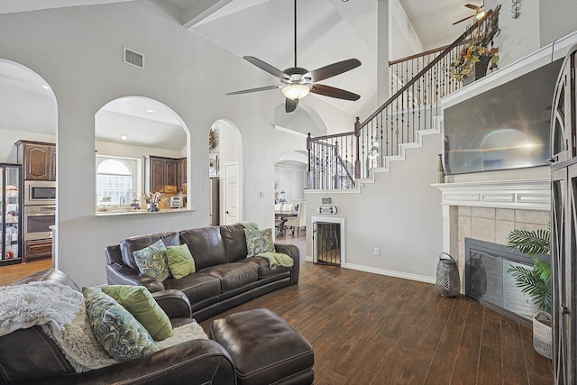 living room featuring a tile fireplace, high vaulted ceiling, ceiling fan, and dark hardwood / wood-style flooring