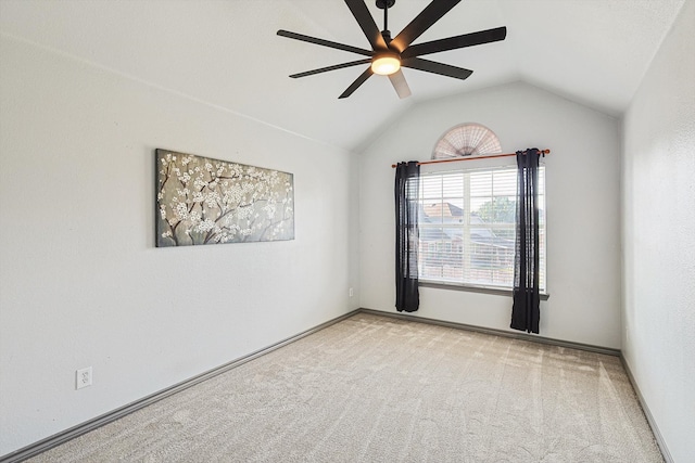 spare room featuring baseboards, a ceiling fan, carpet, and vaulted ceiling