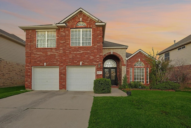 view of front facade featuring a garage, a lawn, and french doors