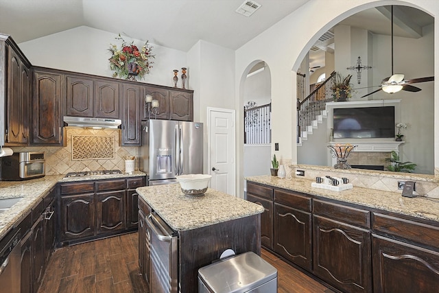 kitchen featuring visible vents, under cabinet range hood, stainless steel appliances, dark brown cabinets, and dark wood-style flooring