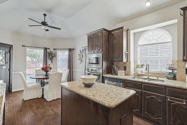 kitchen with sink, dark brown cabinets, dark hardwood / wood-style flooring, a kitchen island, and stainless steel appliances