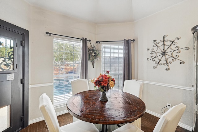 dining area with baseboards and dark wood-type flooring