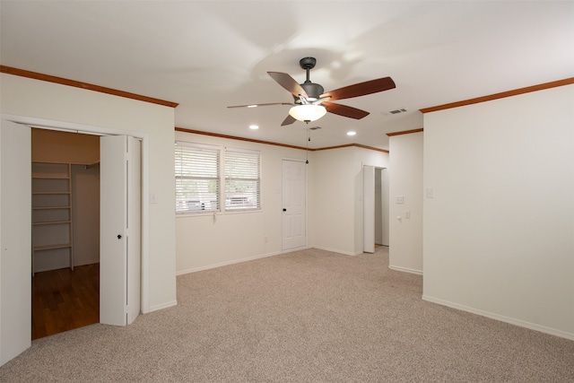 spare room featuring ceiling fan, light colored carpet, and ornamental molding